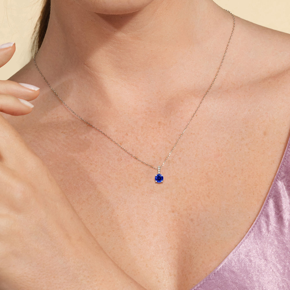 Model Wearing Round Created Sapphire and Lab Diamond Classic Solitaire Pendant With Studded Bale view