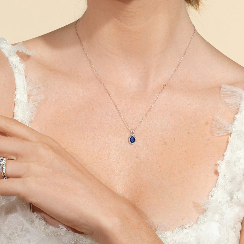 Model Wearing Oval Sapphire and Lab Diamond Classic Halo Pendant With Studded Split Bale view